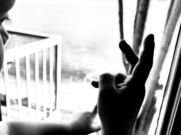toddler fingers in front of a window