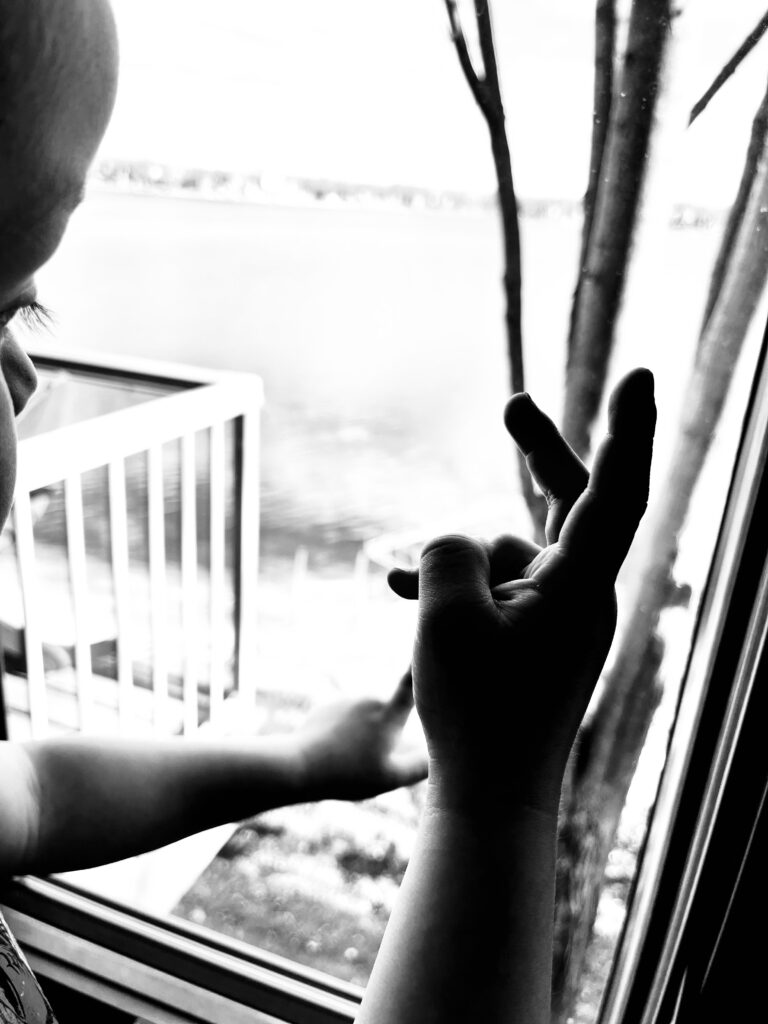 toddler fingers in front of a window